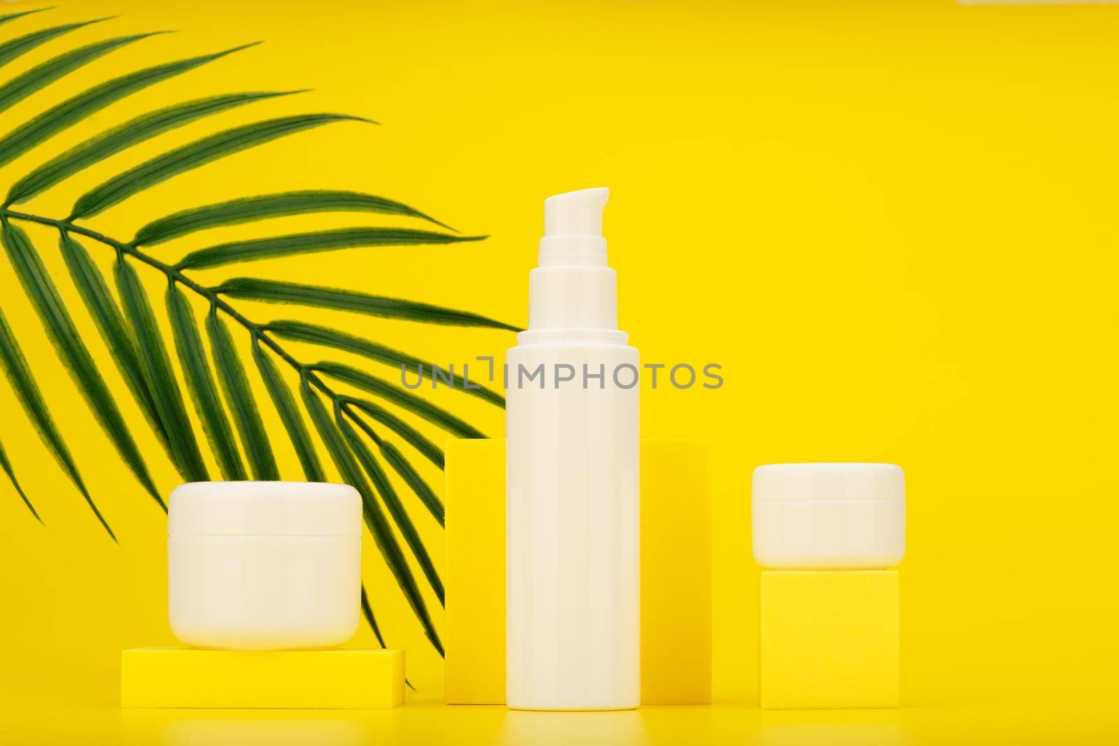 Set of cosmetic products for summer skin care against yellow background with palm leaf.  by Senorina_Irina