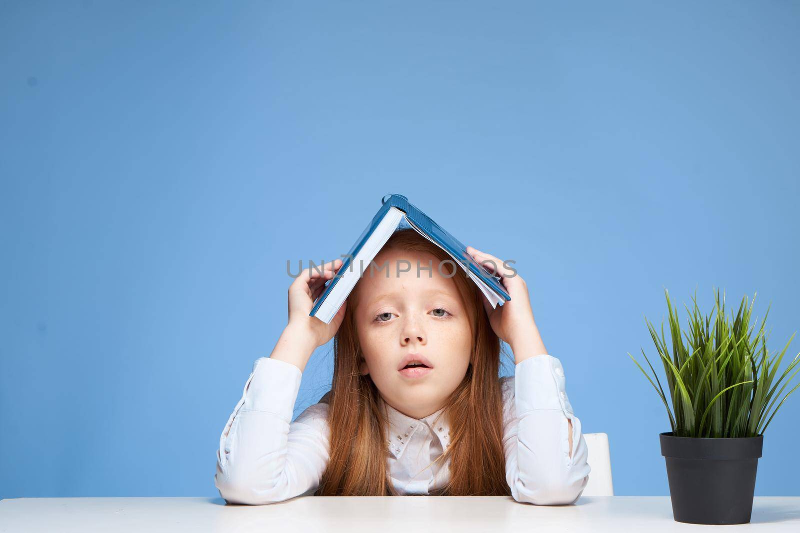 schoolgirl with a book on her head learning lessons lifestyle by SHOTPRIME