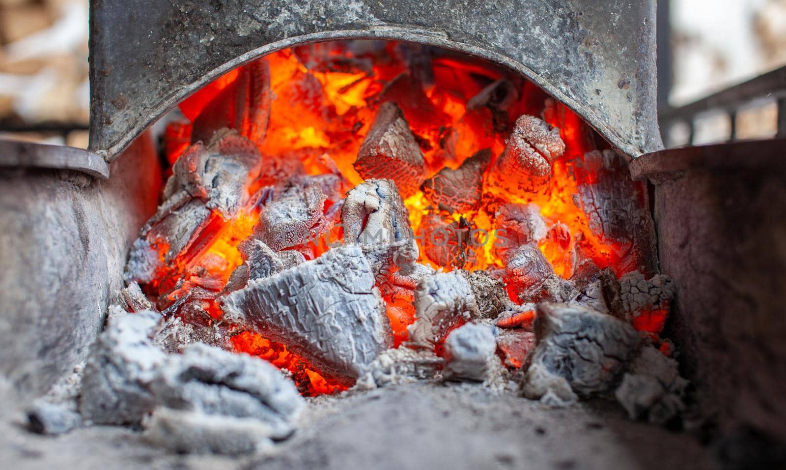 Burning coals in a metal grill for frying meat and vegetables. Cooking on a campfire.