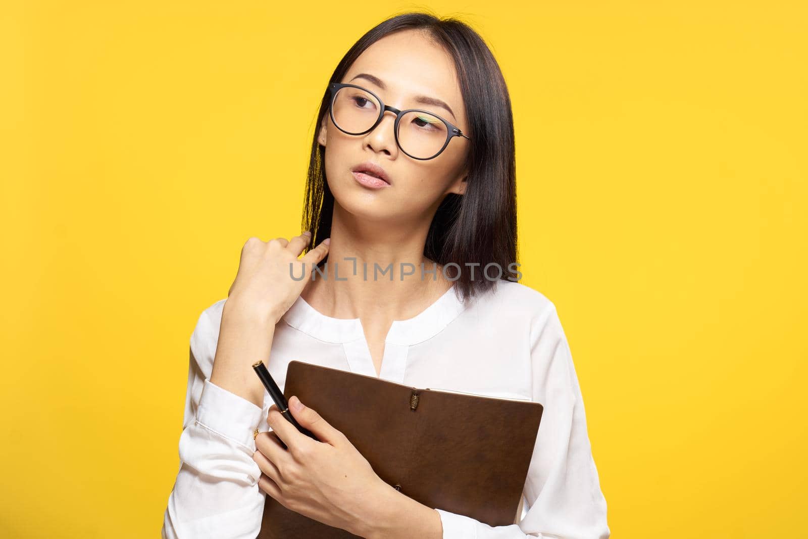 elegant woman with notepad in hands official office yellow isolated background. High quality photo