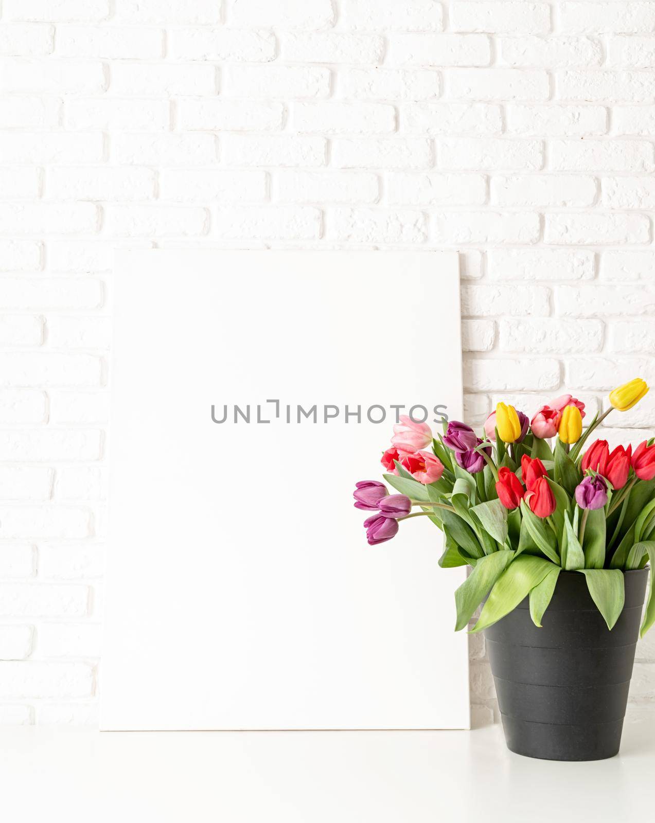 Mock up design. Mock up with Frame and bucket of tulips on white brick wall background