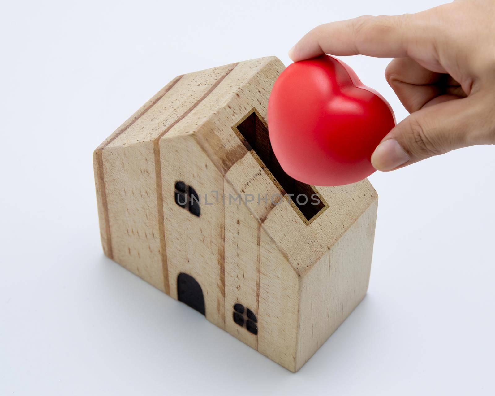 Hand holding red heart put in home isolated on white background, saving with real property, family and love, volunteer and donate, estate and residential and insurance, relationship in family concept.