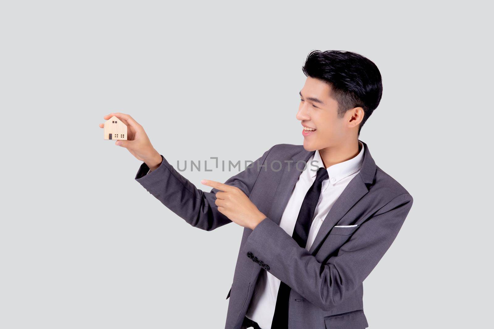 Young asian business man holding the home symbol of saving for future, insurance agent and credit, ownership house, debt and loan of finance, purchase home and refinance, investment real property.
