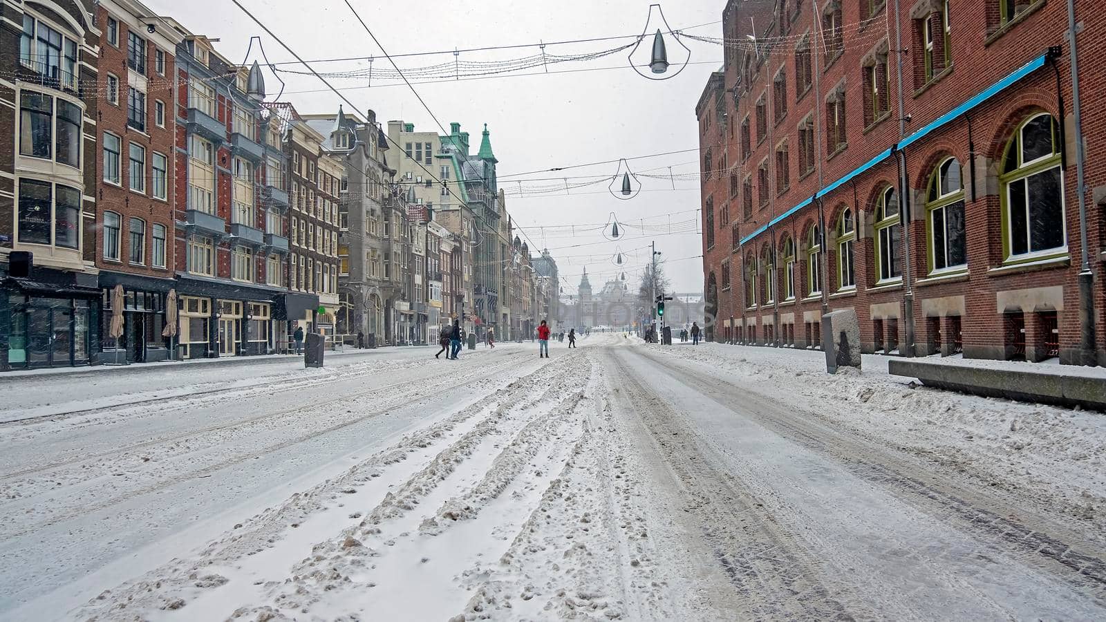 Snowy city Amsterdam at the Damrak in winter in the Netherlands by devy