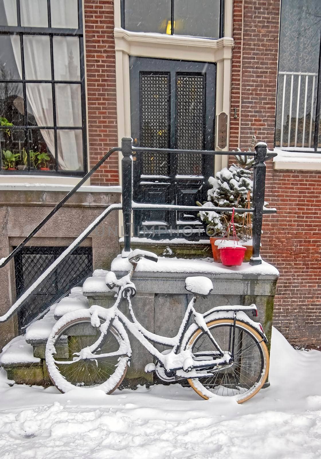 Snowy bike in front of a traditional house in Amsterdam the Netherlands by devy