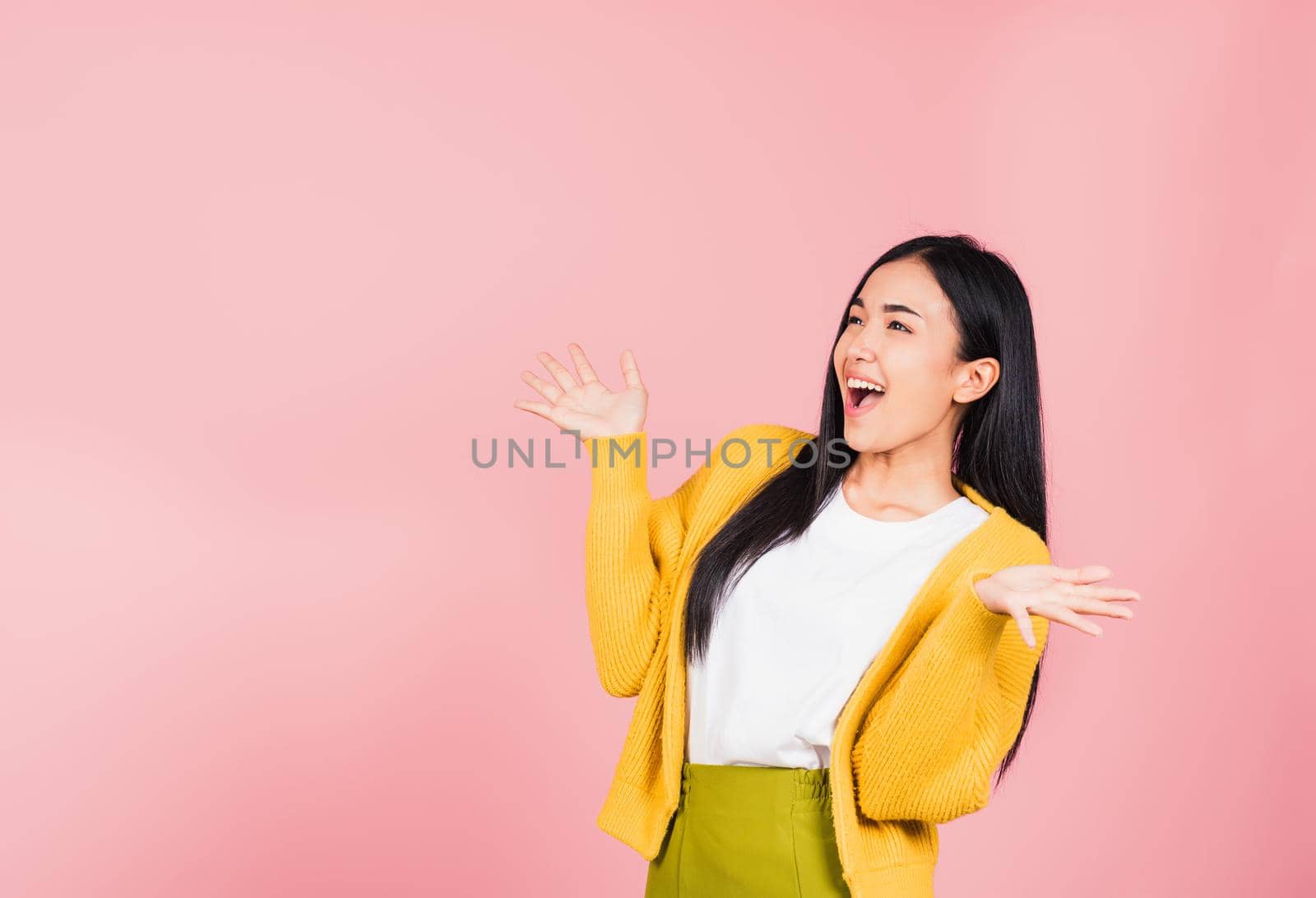 Happy Asian portrait beautiful cute young woman standing winning and surprised excited screaming open mouth raise hands, studio shot isolated pink background, Thai female wow with copy space