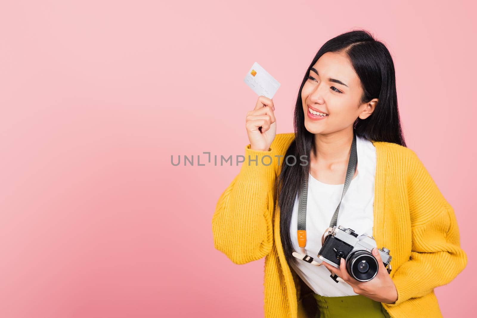 Happy Asian portrait beautiful young woman excited smiling photographer holding credit credit card bank and retro vintage photo camera ready travel isolated on pink background, tourism and vacation