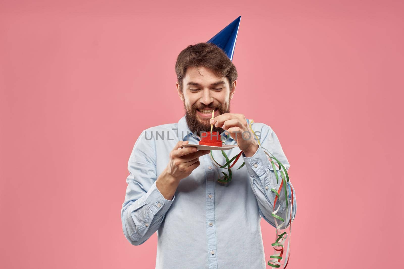 Birthday of a man with a cake and with a candle on a pink background by SHOTPRIME