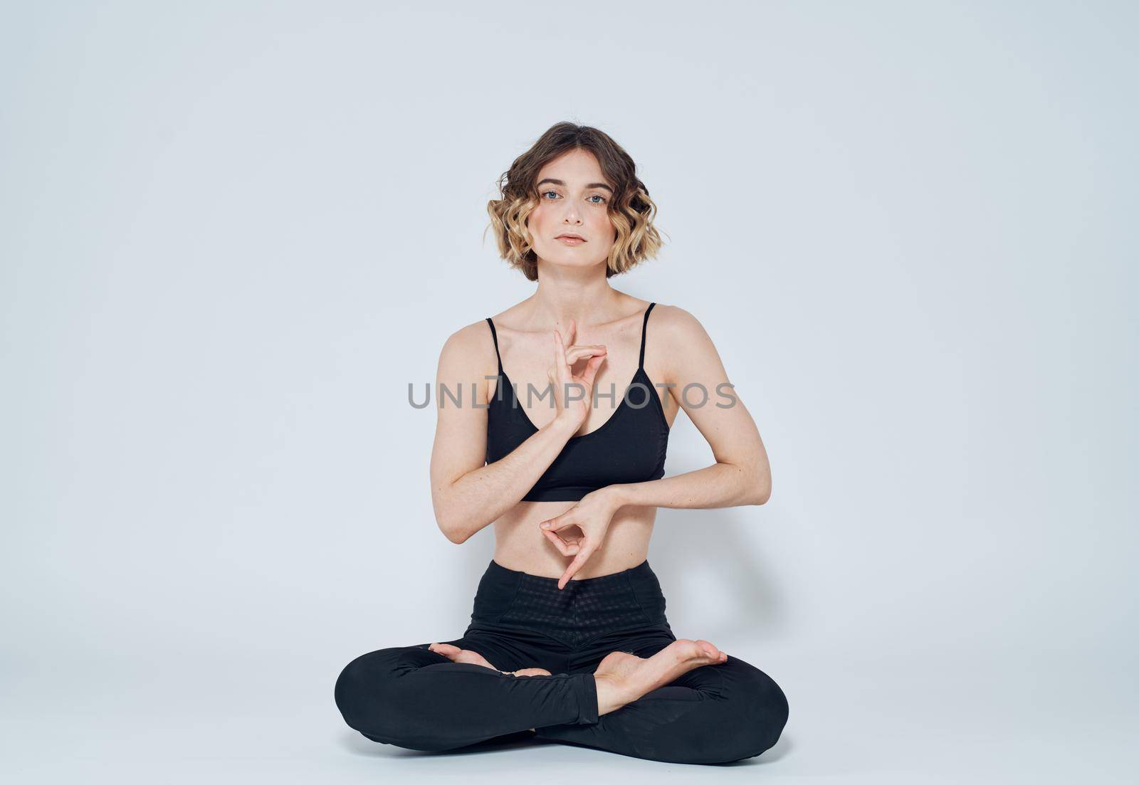 Woman meditates on a light background yoga asana. High quality photo