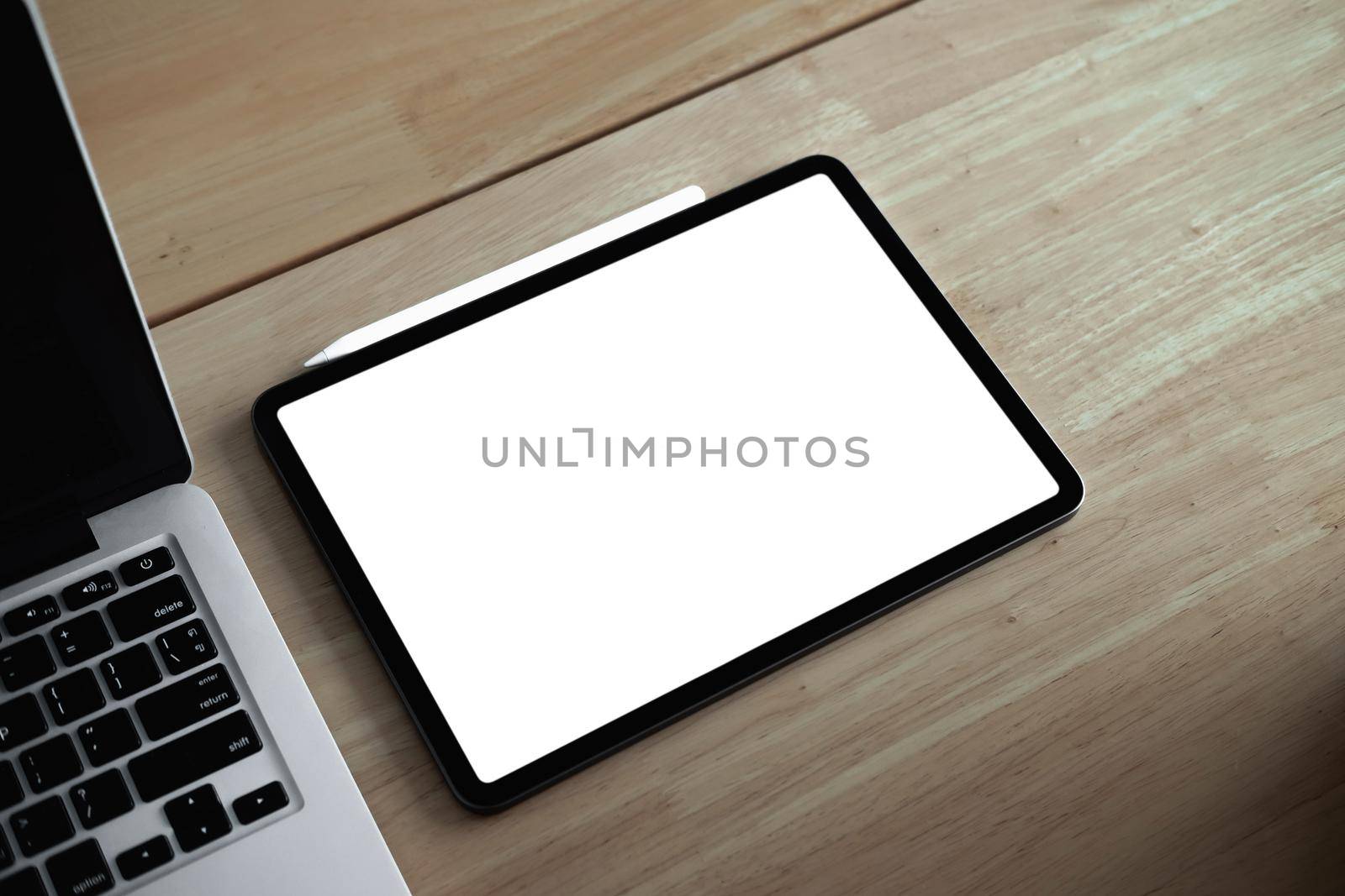 Cropped shot of mock-up digital tablet with blank white screen on desk