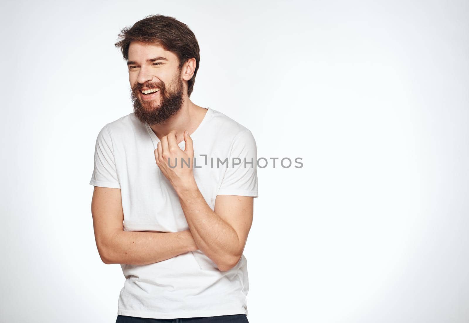 Emotional guy in a white t-shirt on a light background emotions model cropped view of a student. High quality photo