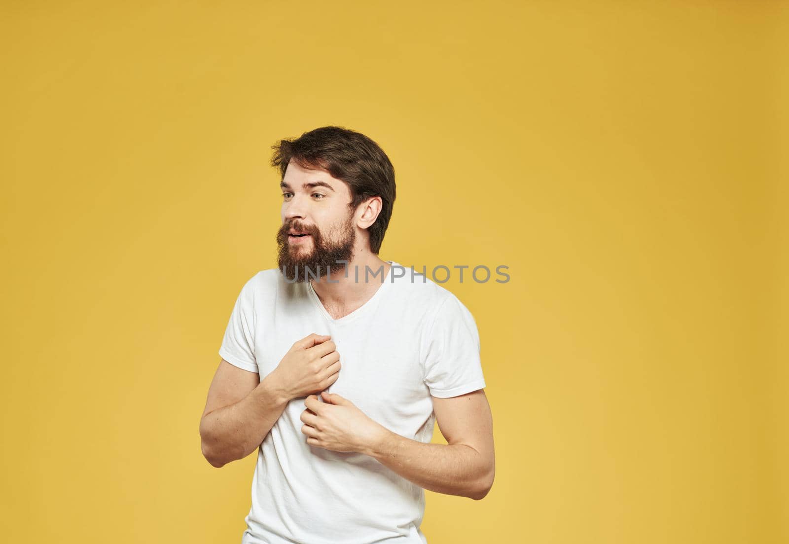 male model gesturing with his hands on a yellow background cropped view Copy Spac. High quality photo