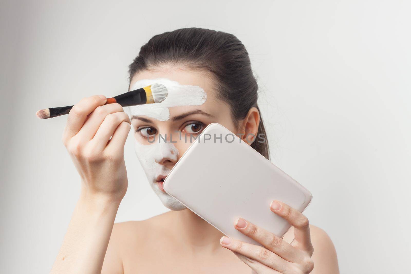 pretty woman applying brush cream on face skin care rejuvenation. High quality photo