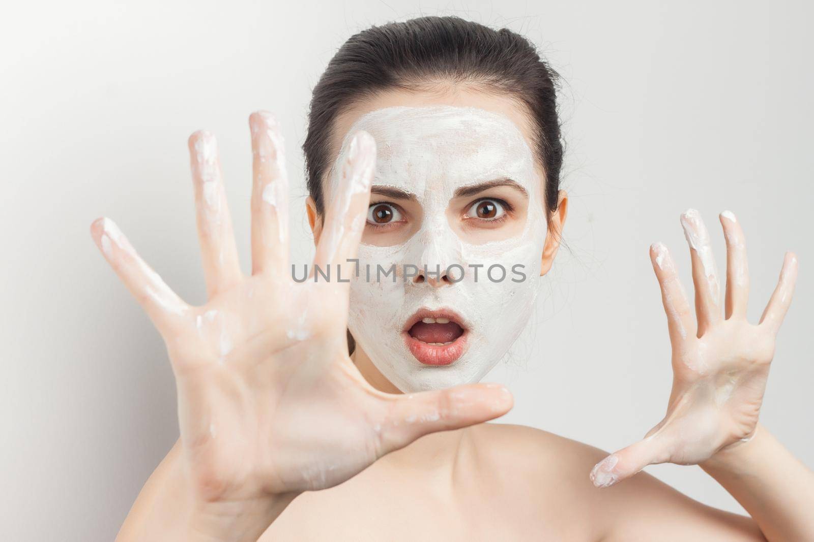 pretty woman applying makeup brush on face skin care naked shoulders. High quality photo