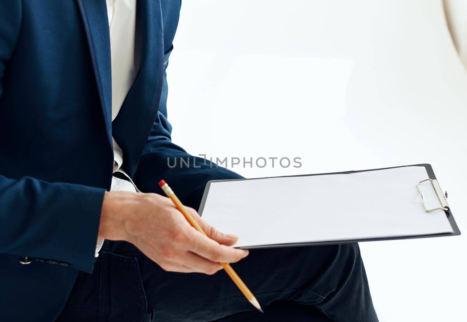 Business man in a suit with documents writes down important information. High quality photo