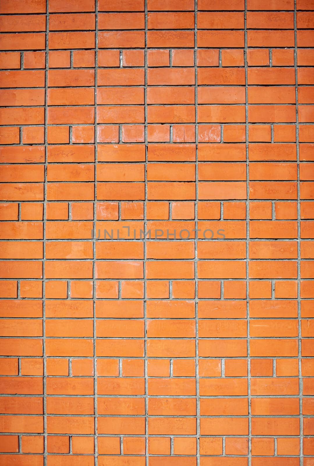 A new, smooth red brick wall. The bricks are laid in rows. Grunge stone texture. There is a place for the text