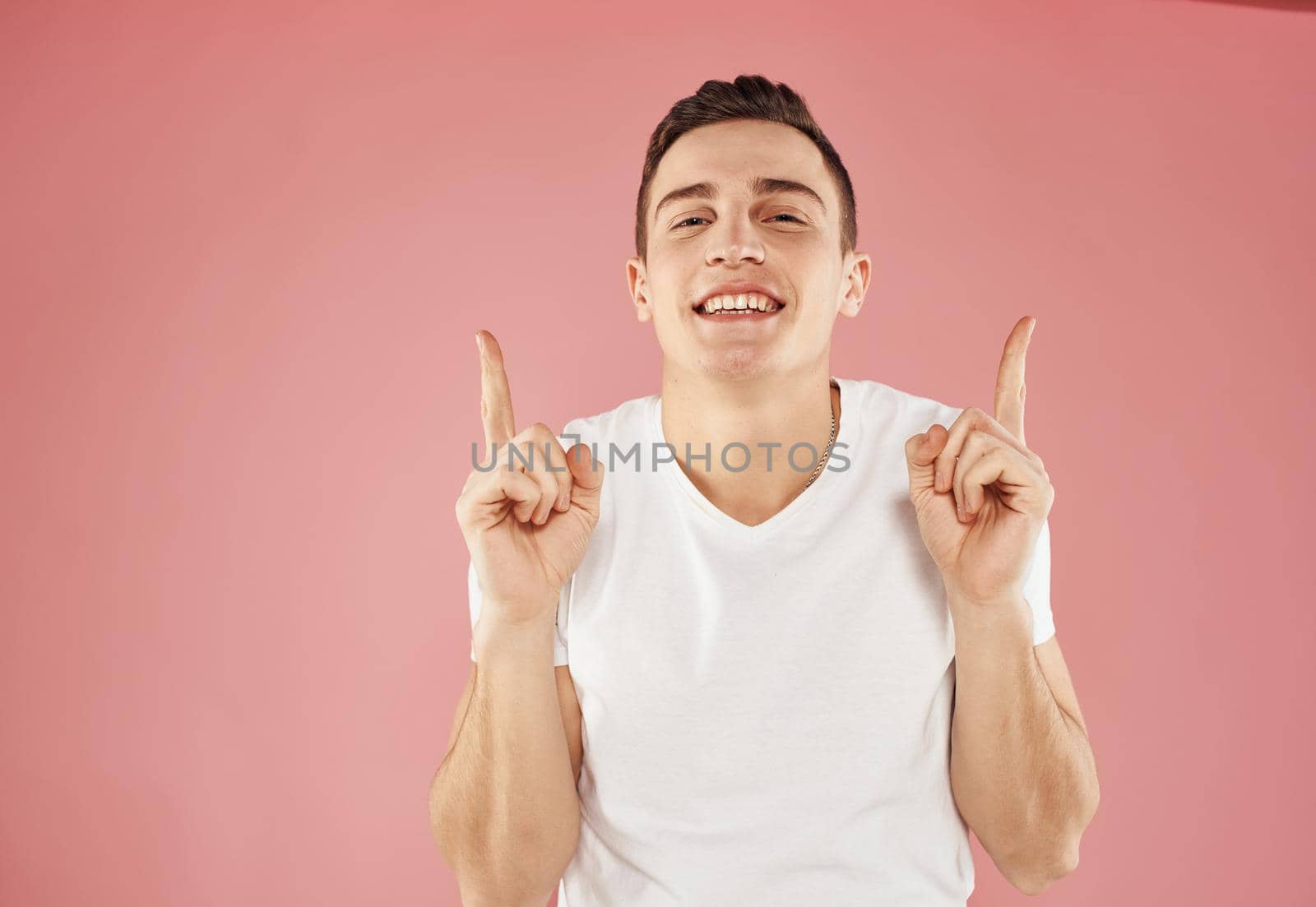 happy guy gesturing with his hands and showing fingers to the side emotions model. High quality photo