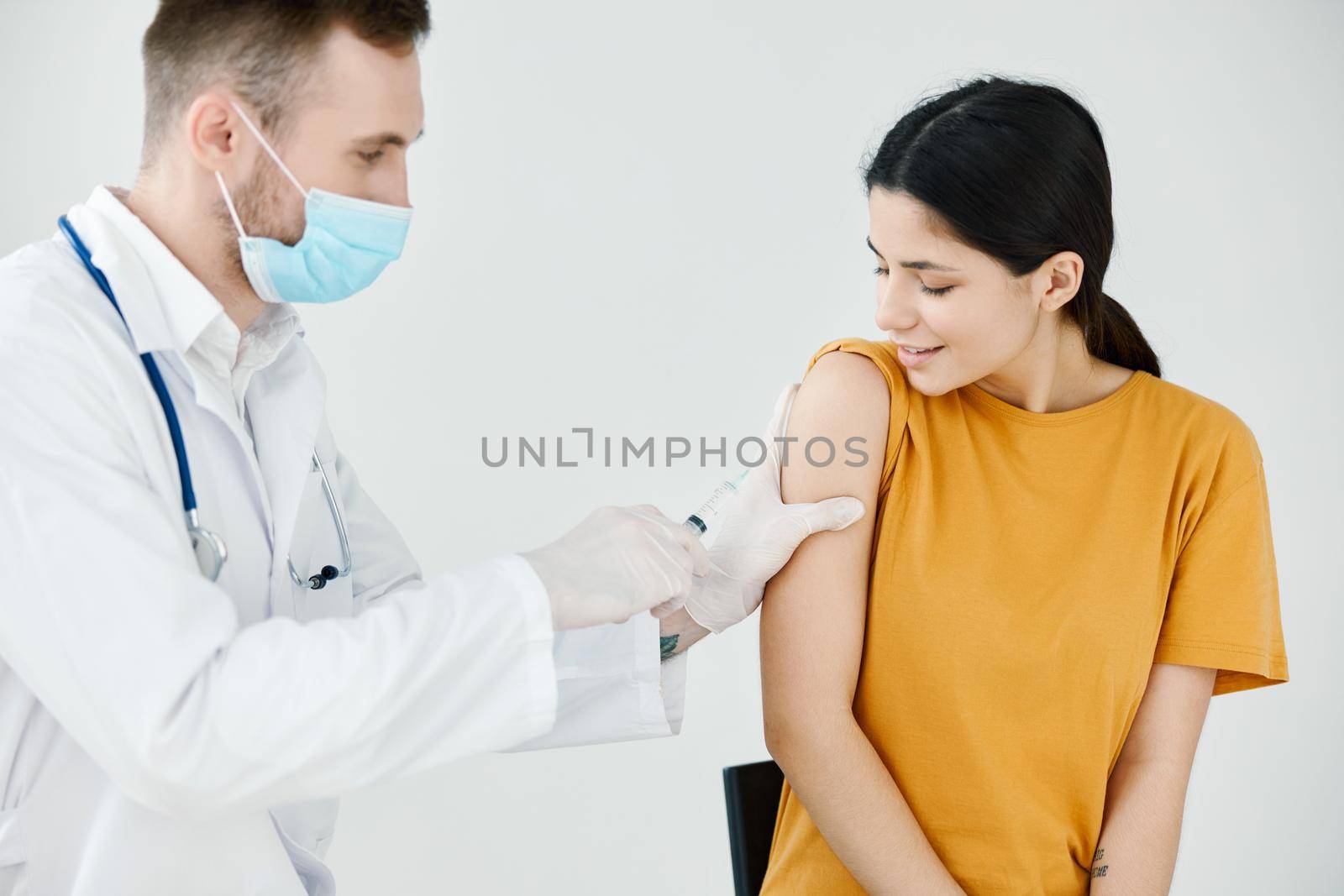 the doctor tapes the injection on the patient's shoulder with adhesive tape. High quality photo