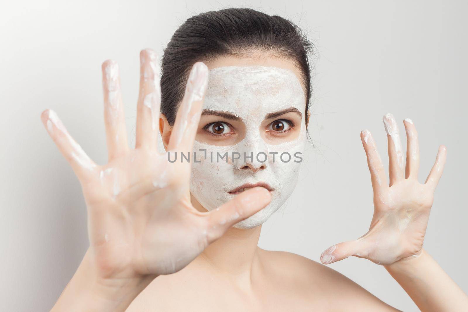 pretty brunette naked shoulders face mask brush in hands skin care procedures. High quality photo