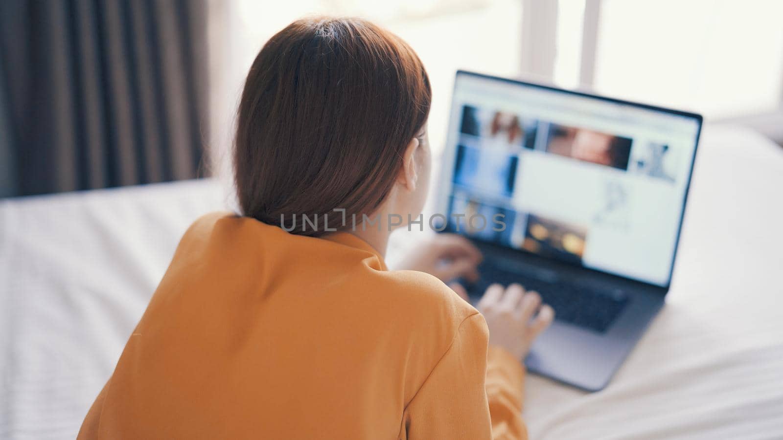 woman in front of laptop lying in bed at home internet communication. High quality photo