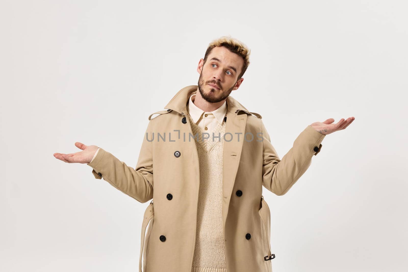 man gesturing with his hands fashion beige coat modern style studio by SHOTPRIME