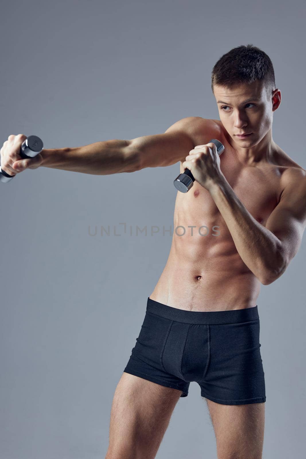 sporty man inflated torso dumbbells in hand workout . High quality photo