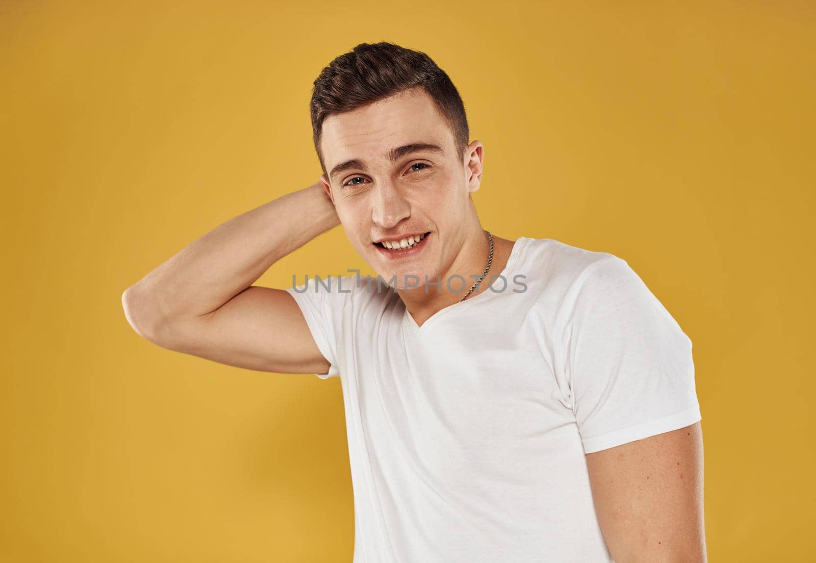 Portrait of a handsome guy in a white t-shirt on a yellow background cropped view by SHOTPRIME