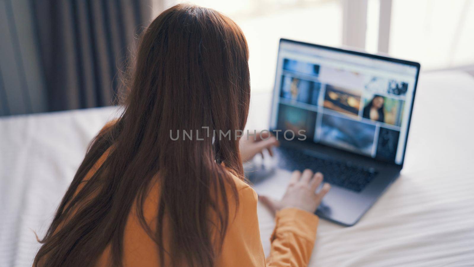 woman lying in bed in front of laptop working at home internet. High quality photo