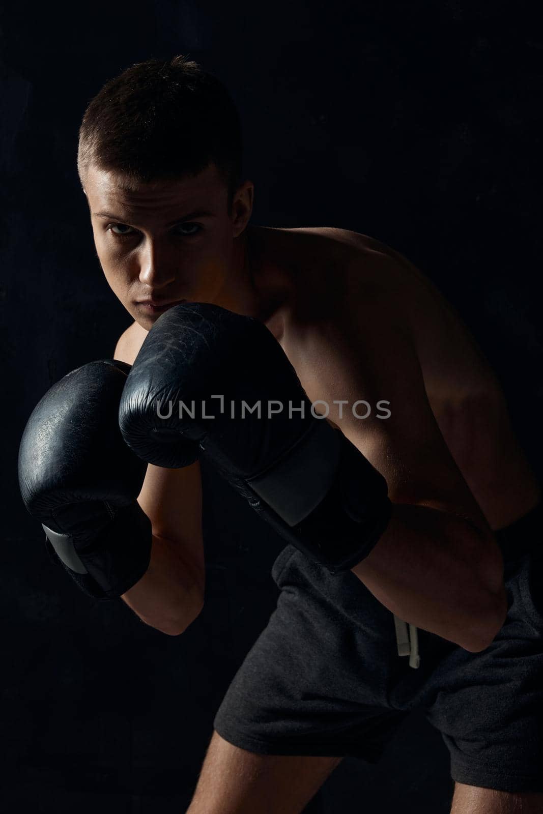 man in boxing gloves on black background workout bodybuilder fitness. High quality photo