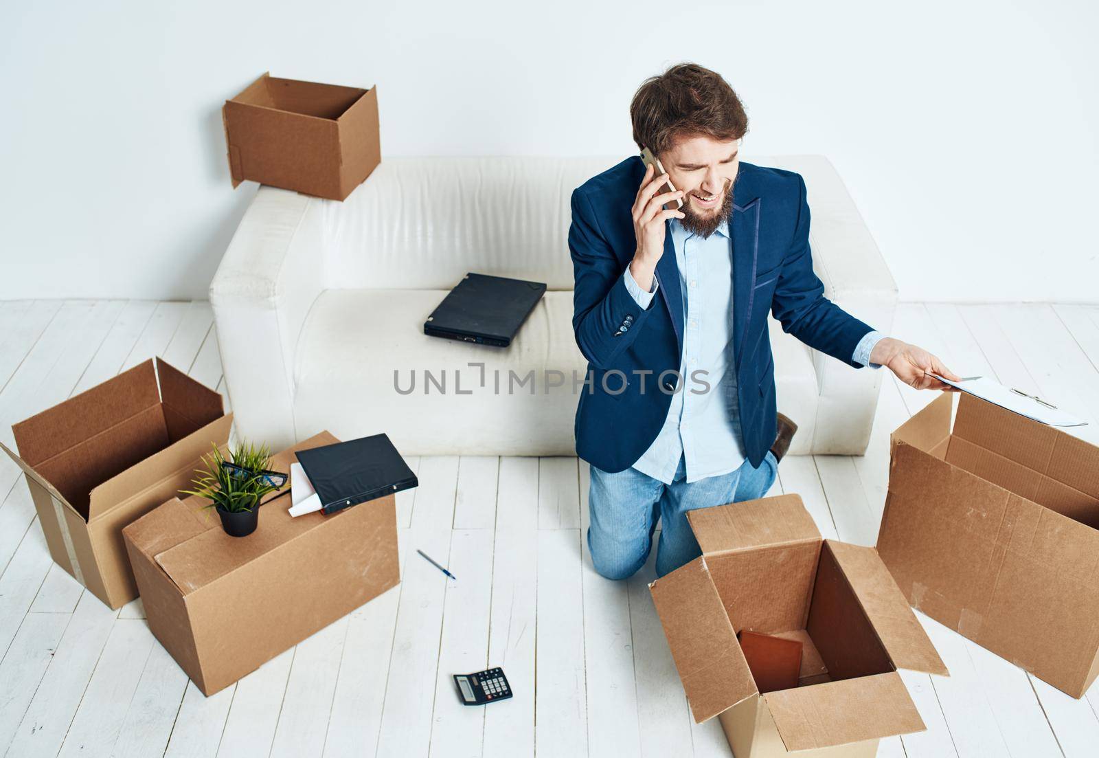 man talking on the phone unpacking boxes office work new place businessman. High quality photo