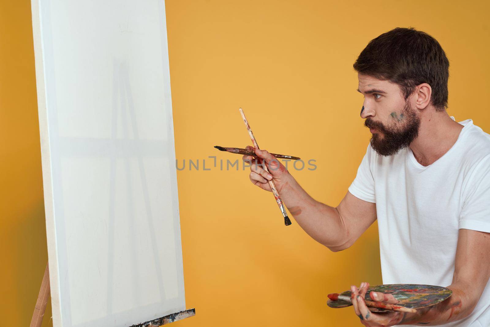 Bearded male artist easel for drawing art palette. High quality photo