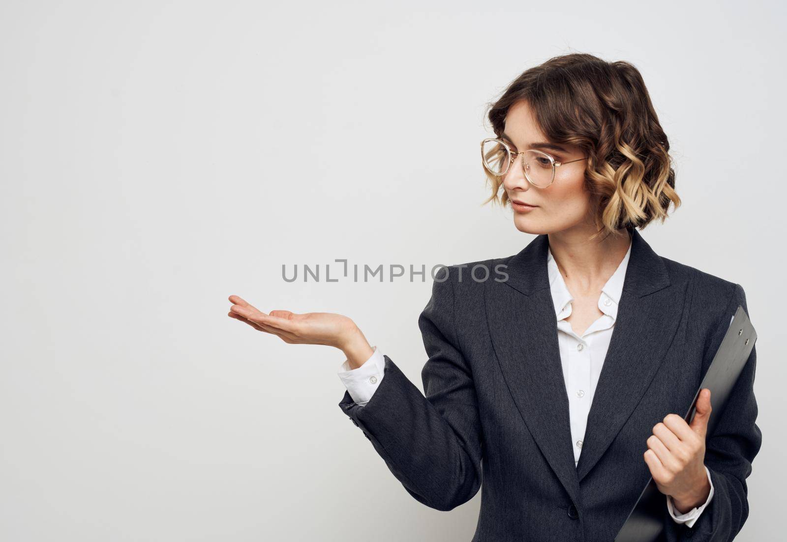 Woman in classic suit shows business financial documents and Copy Space with her hand. High quality photo