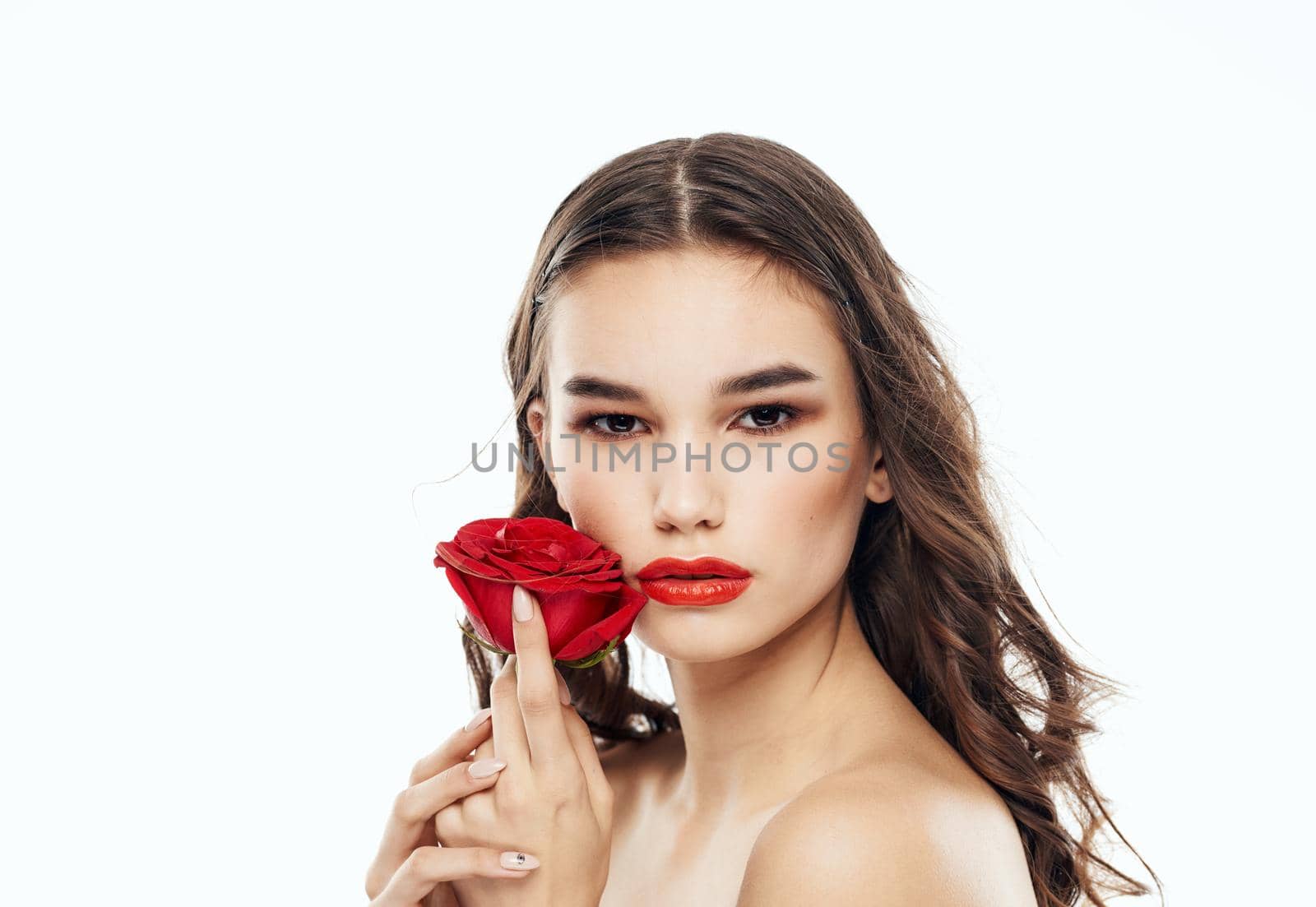 Charming woman clean skin cosmetology bright makeup and red flower. High quality photo