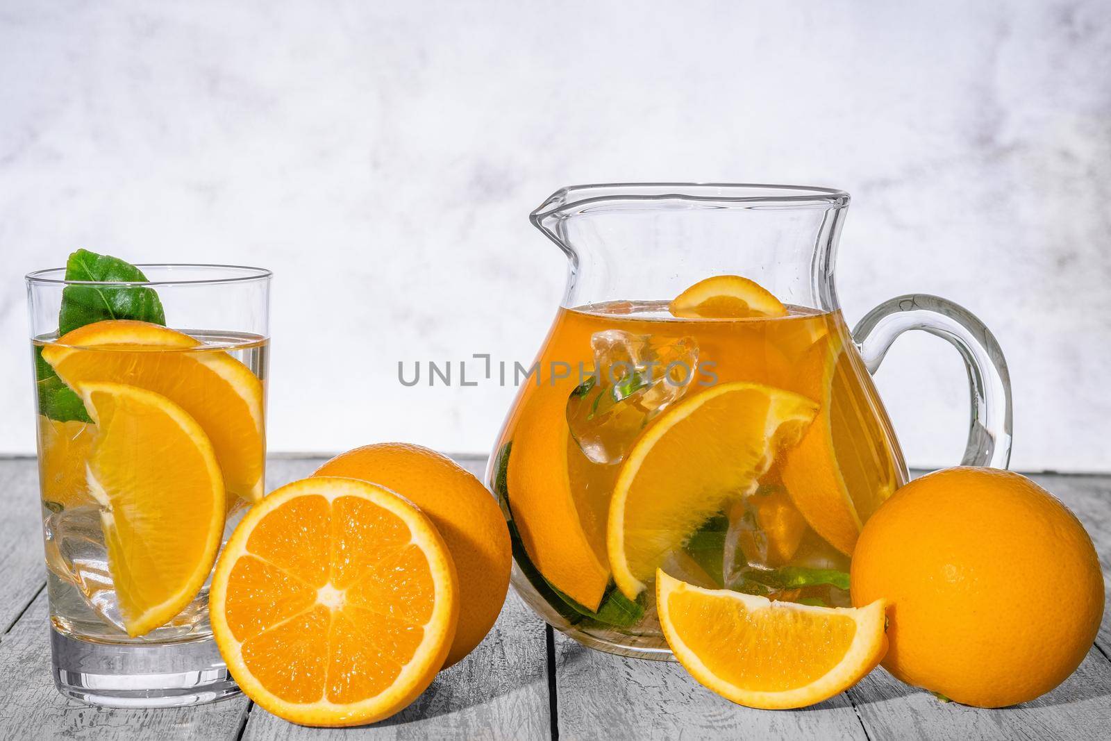 Healthy orange detox with fresh orange and lime, in glass on wooden Background.