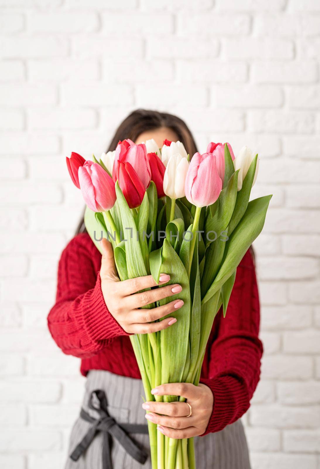Woman florist making a bouquet of fresh colorful tulips by Desperada