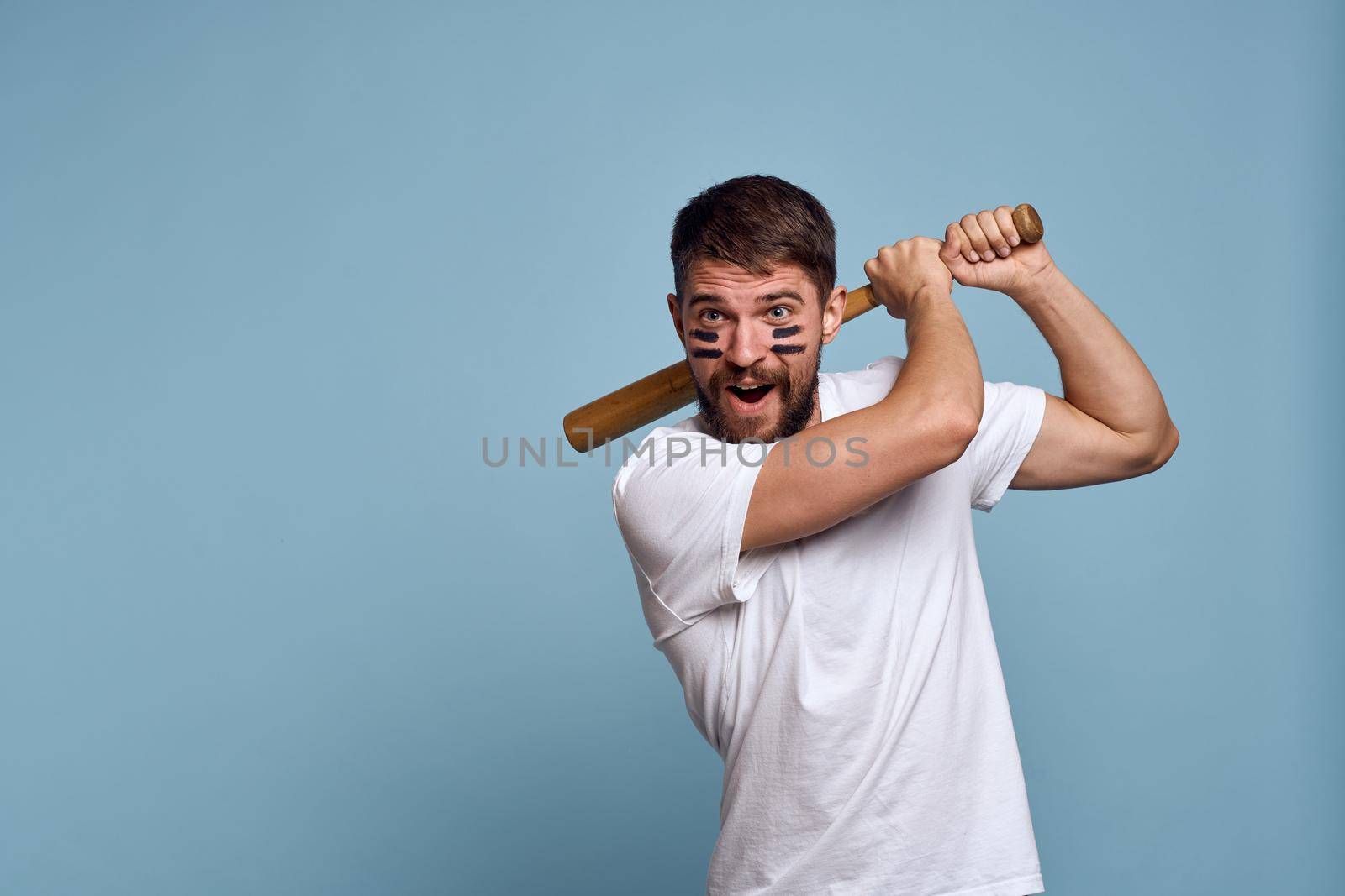 Man in white t-shirt baseball bat sport blue background. High quality photo