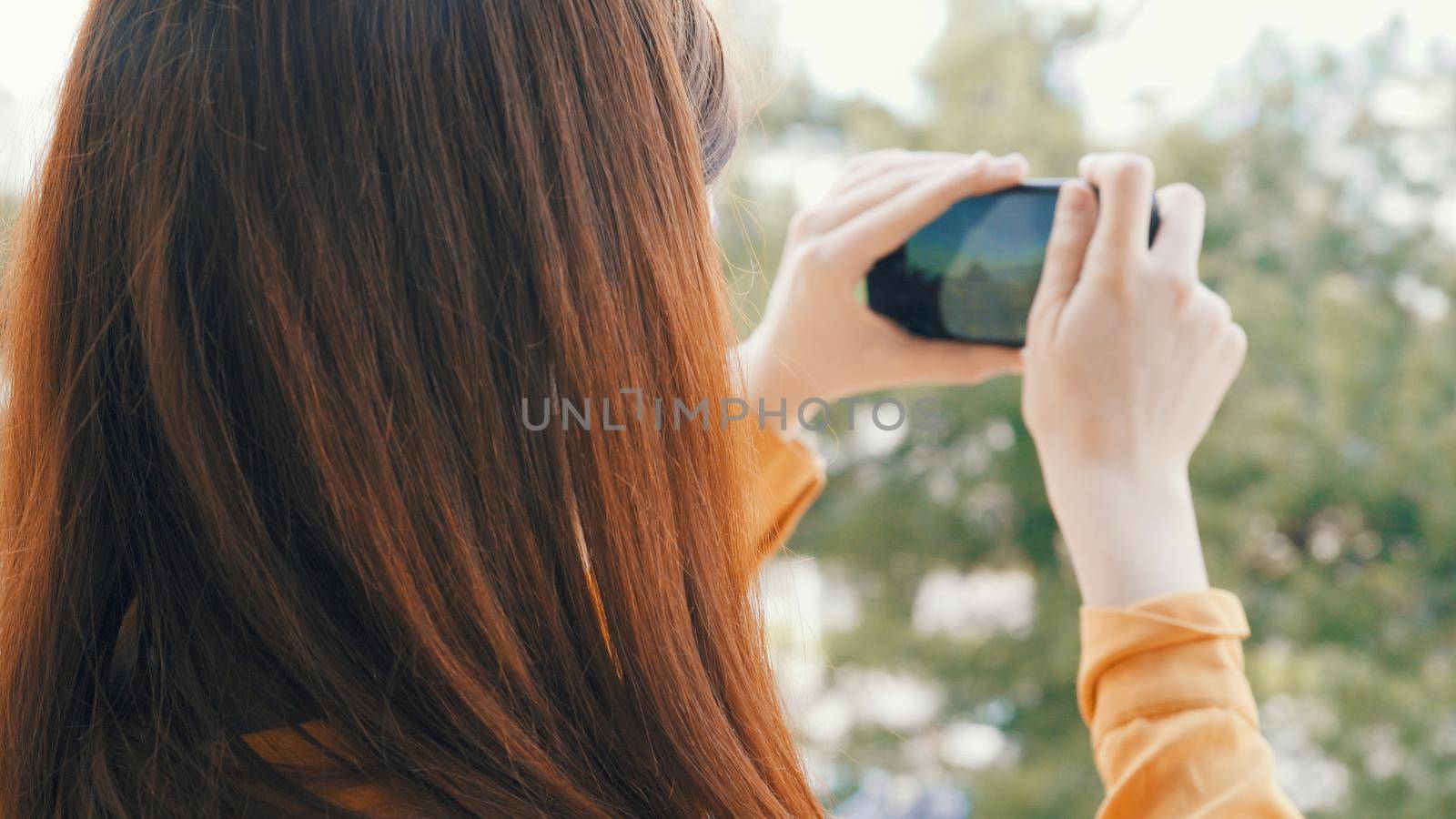 woman with phone in hand takes pictures of nature on camera vacation landscape. High quality photo