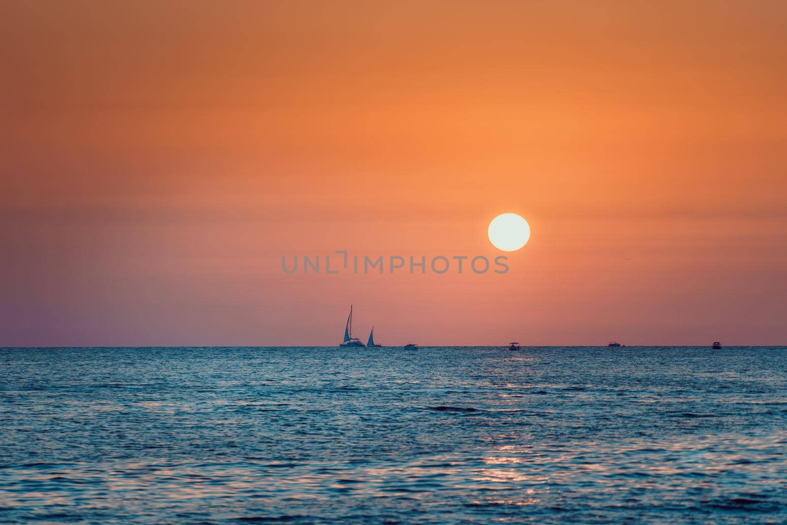 Bright sunset on the sea background sea and boats in the blue sea