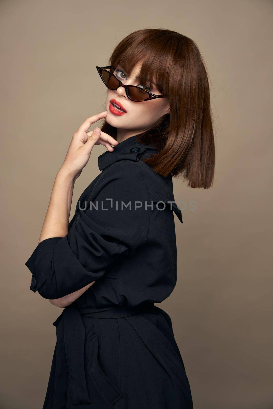 Charming brunette touches her face with her hand and looks ahead black coat cropped view Copy spaces