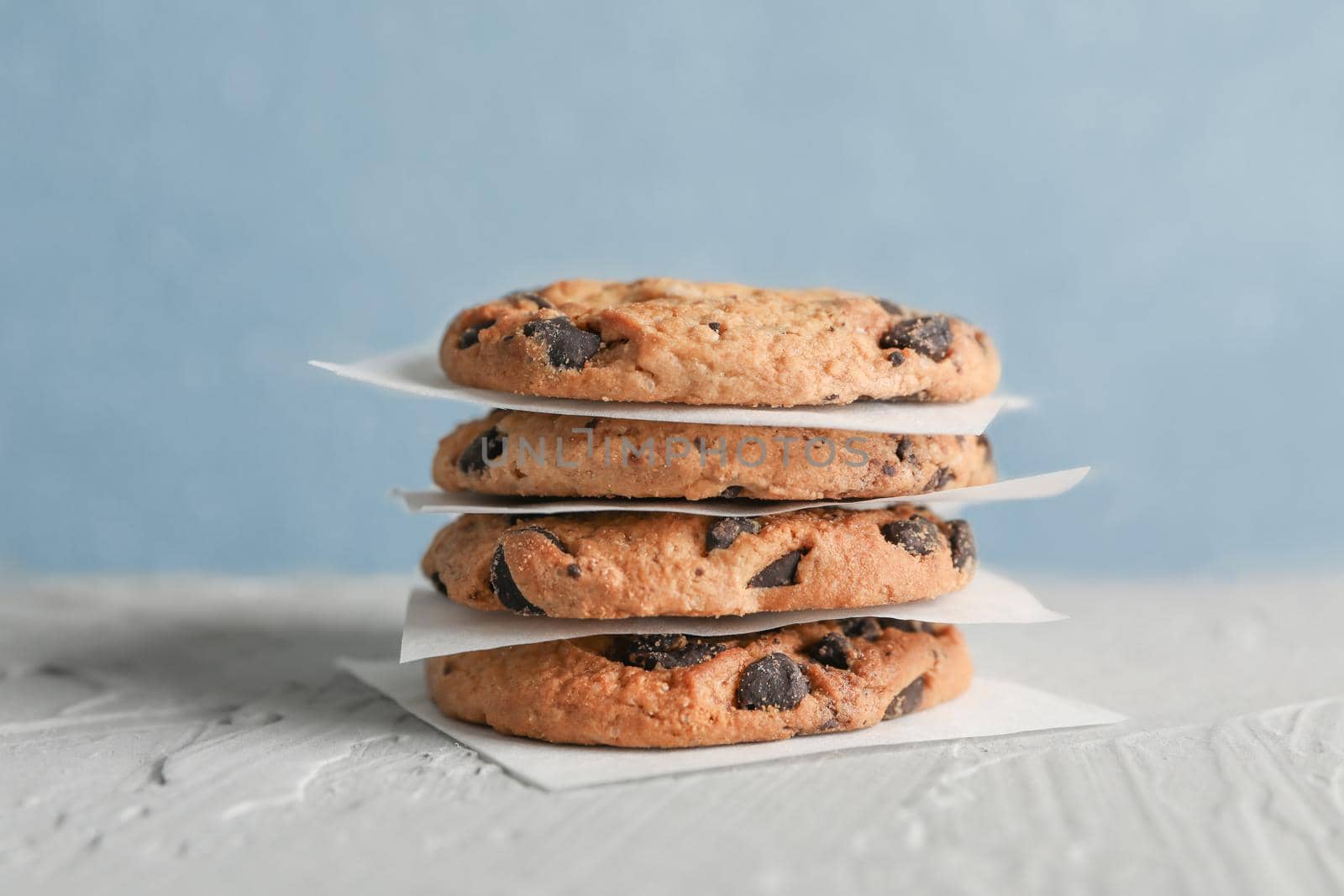 Tasty chocolate chip cookies on gray background