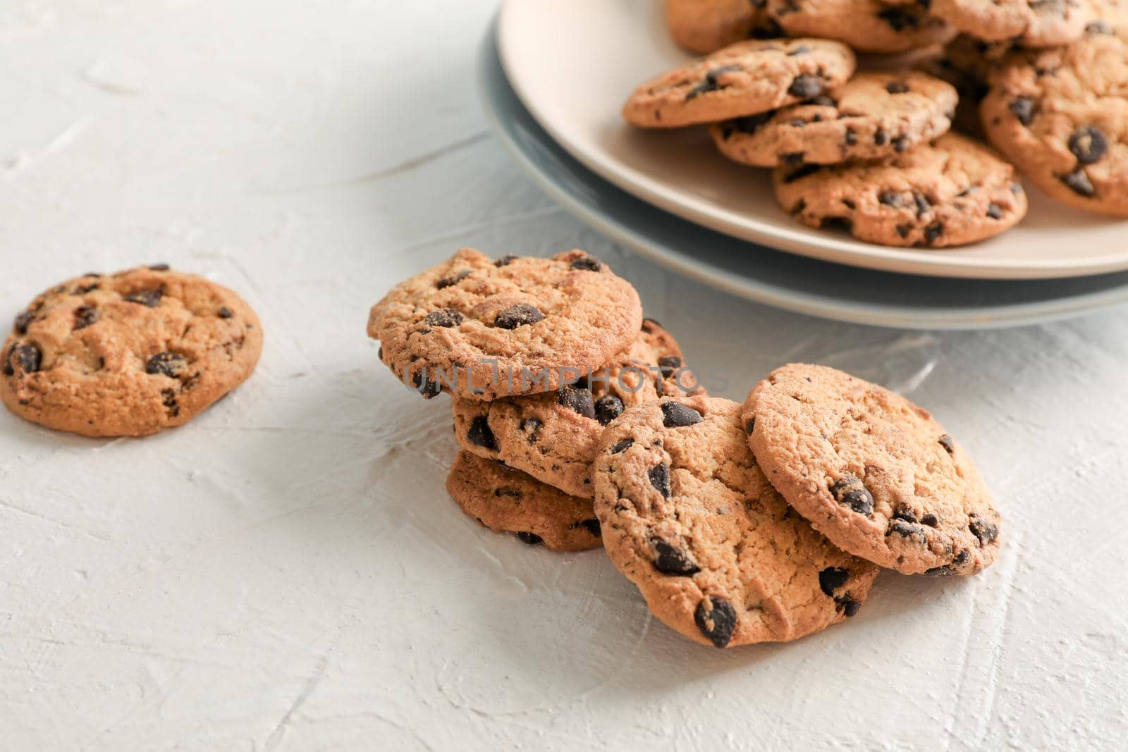 Plate with tasty chocolate chip cookies  on gray background. Space for text