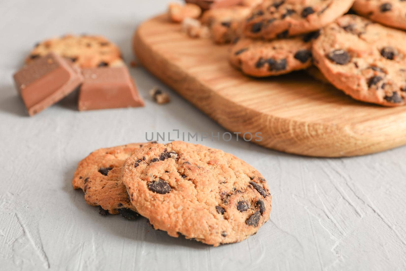 Tasty homemade chocolate chip cookies on gray background