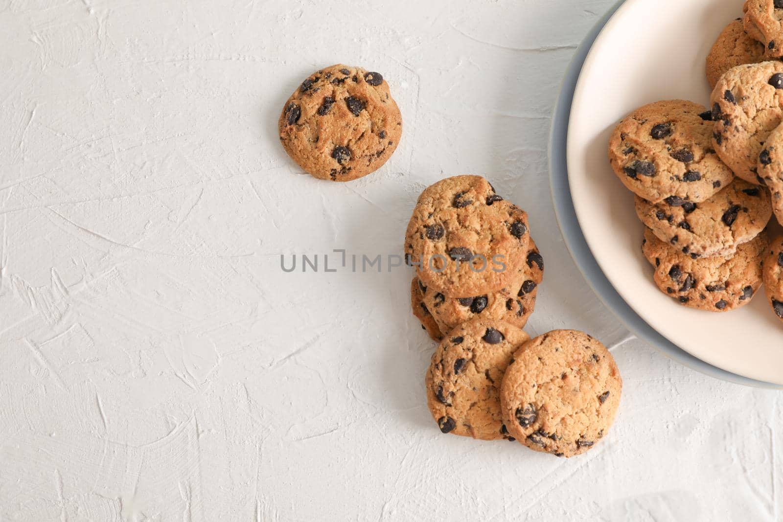 Plate with tasty chocolate chip cookies  on gray background, top view. Space for text by AtlasCompany