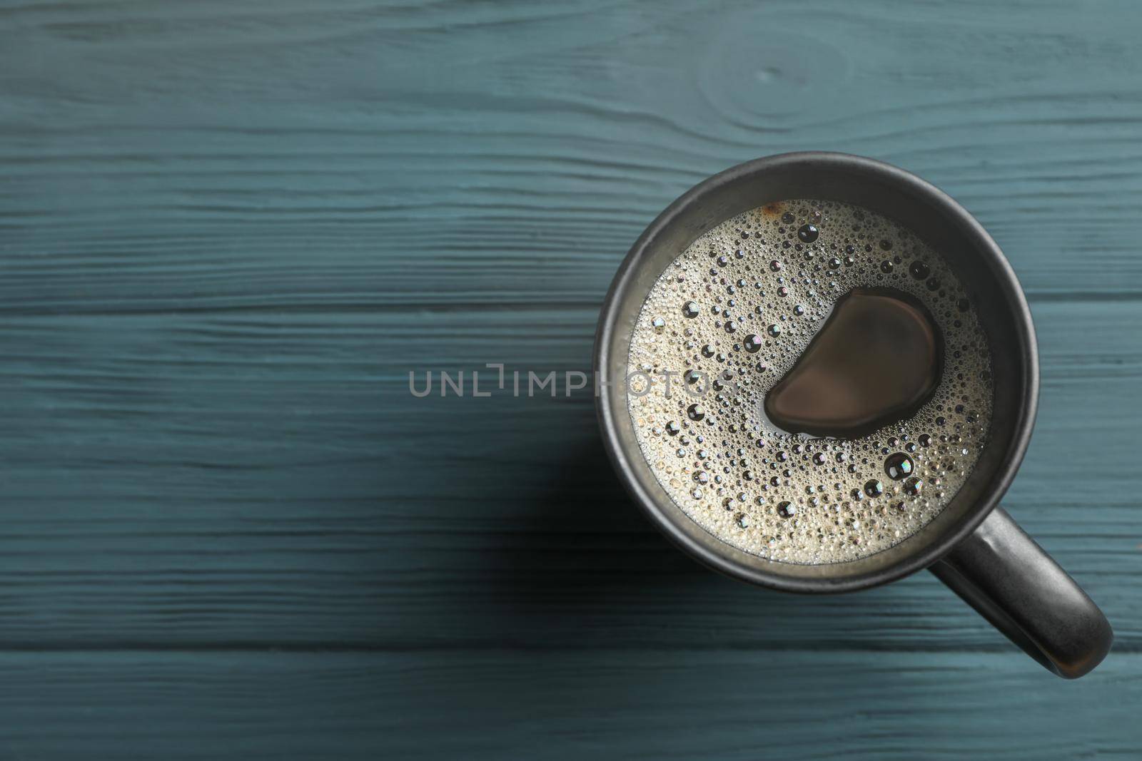 Cup of coffee on wooden background, top view