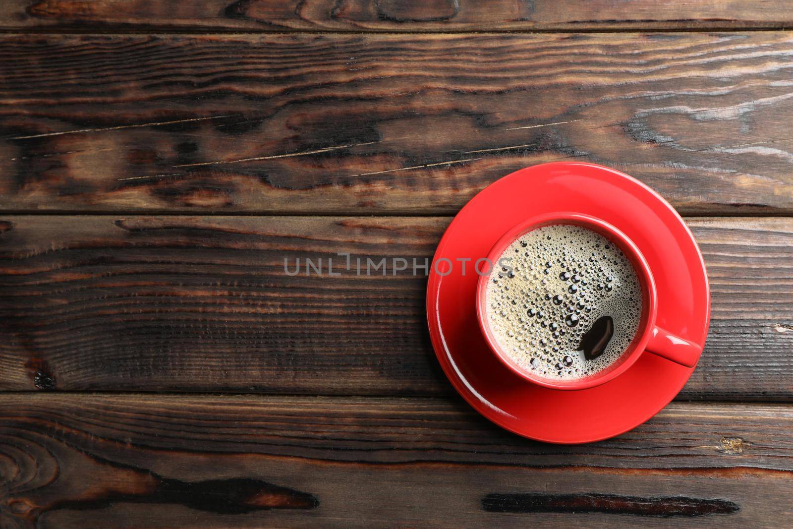 Cup of coffee on wooden background, top view