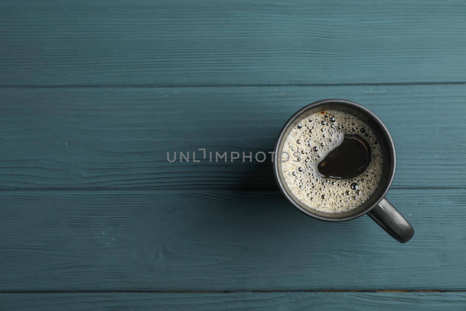 Cup of coffee on wooden background, top view