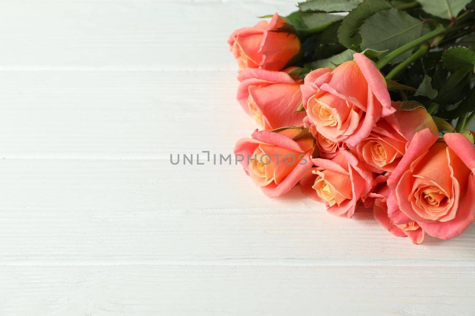 Bouquet of fresh pink roses on wooden background, closeup