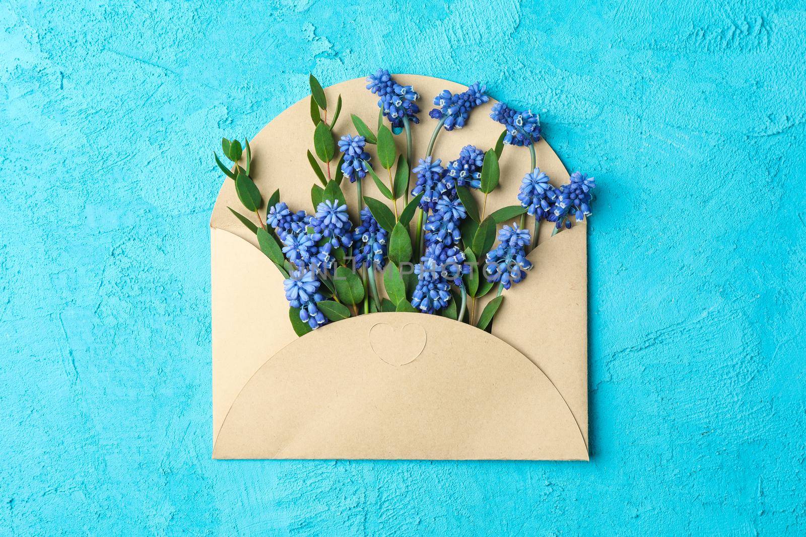 Letter with fresh hyacinths on blue background, top view by AtlasCompany