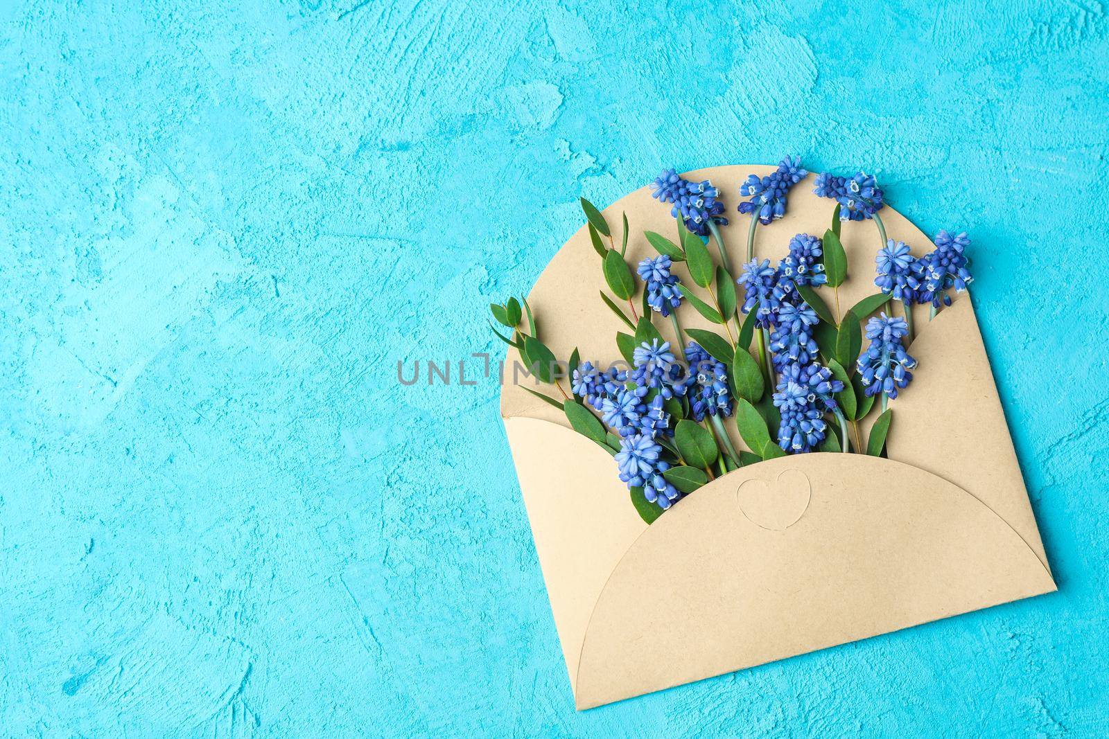 Letter with fresh hyacinths on blue background, space for text