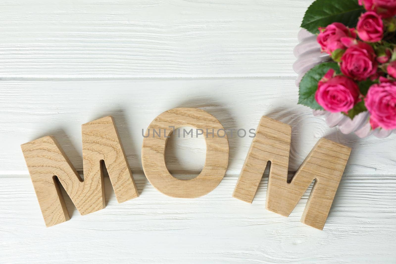 Composition with inscription Mom and pink roses on white wooden background, top view by AtlasCompany